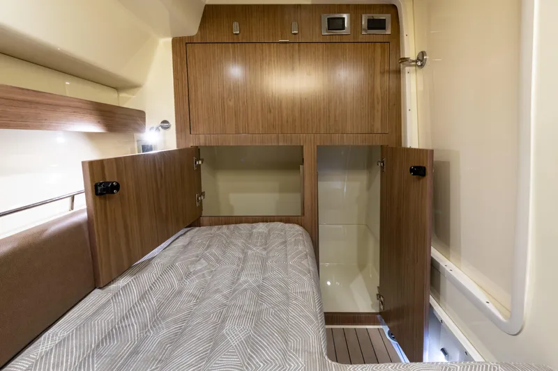 Slide: The Image of 2025 Chris-Craft Calypso 35 cabin interior with wood cabinetry and cozy bedding. - 20
