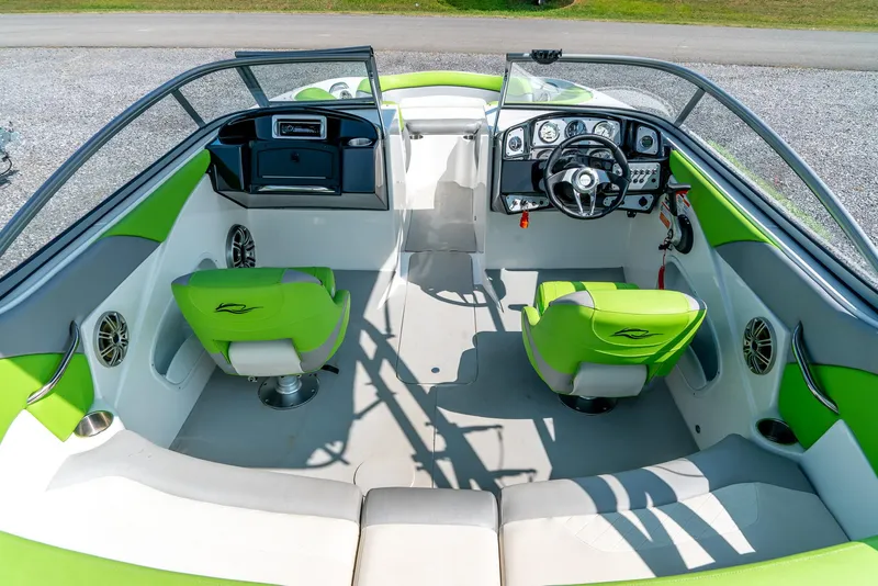 Slide: The Image of 2014 Rinker Captiva 200 MTX boat interior with green and white seating, modern dashboard, and steering wheel. - 11