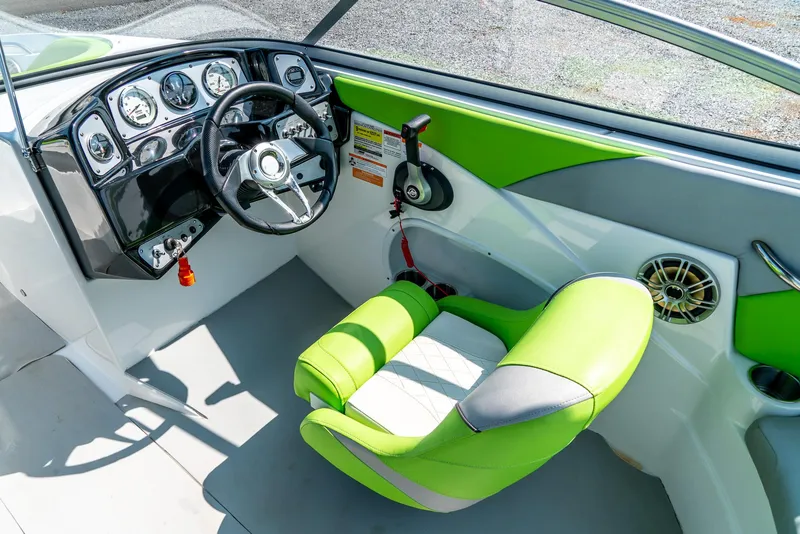 Slide: The Image of 2014 Rinker Captiva 200 MTX boat cockpit with green seat and modern dashboard controls. - 13