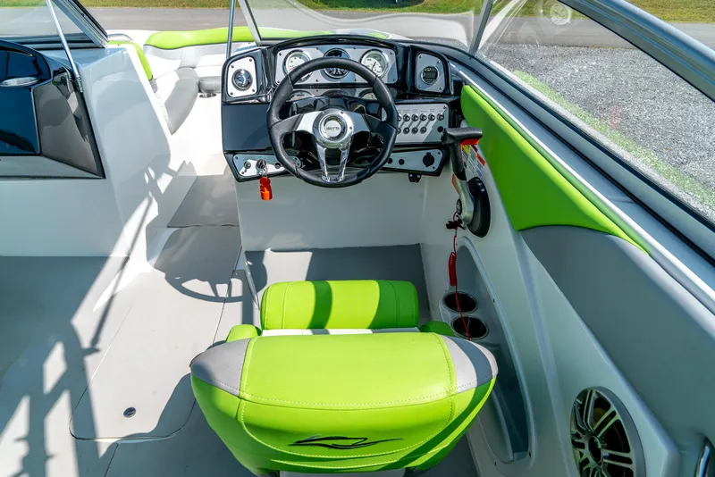 Slide: The Image of 2014 Rinker Captiva 200 MTX boat interior with green and white seating, steering wheel, and dashboard. - 14