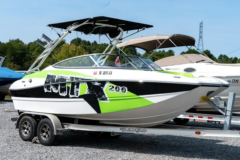 Slide: The Image of 2014 Rinker Captiva 200 MTX boat on trailer, featuring vibrant green and black design. - 3