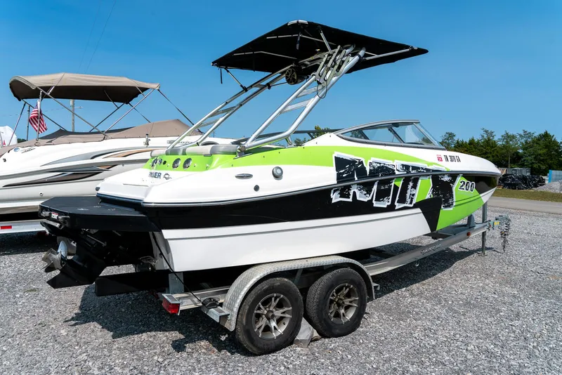 Slide: The Image of 2014 Rinker Captiva 200 MTX boat on trailer, featuring green and black design. - 5