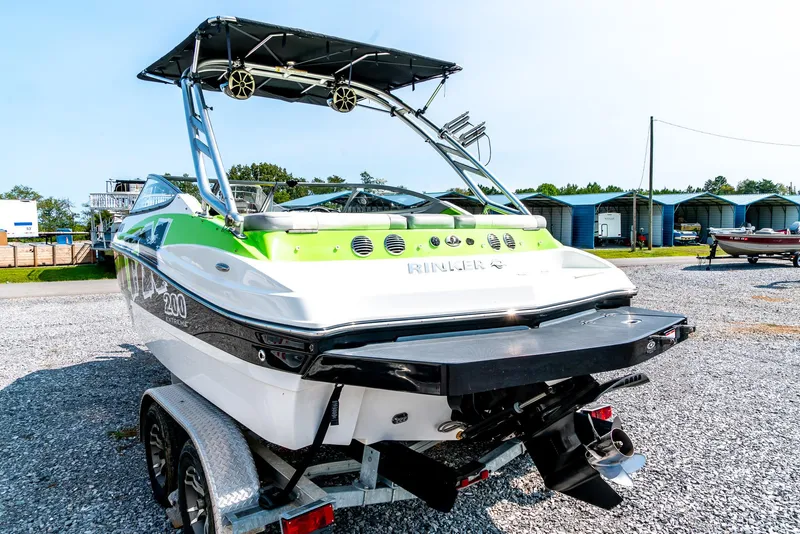 Slide: The Image of 2014 Rinker Captiva 200 MTX boat on trailer, featuring sleek design and vibrant green accents. - 6