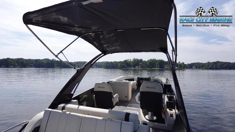 Slide: The Image of 2025 Barletta L25UCAT pontoon boat on a serene lake, featuring spacious seating and canopy. - 12