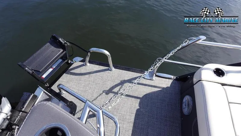 Slide: The Image of Barletta L25UCAT 2025 pontoon boat deck with seating and safety chain on water. - 14