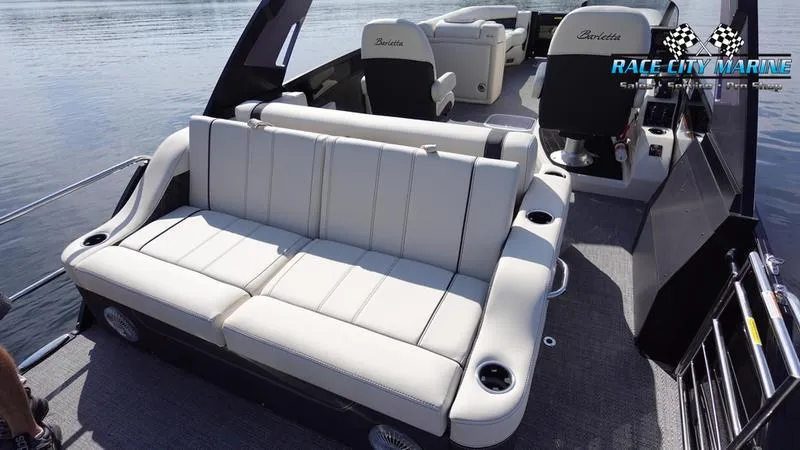 Slide: The Image of 2025 Barletta L25UCAT pontoon boat with luxurious seating on a calm lake. - 20
