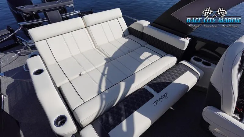 Slide: The Image of 2025 Barletta L25UCAT boat interior with luxurious seating and cup holders on the water. - 21