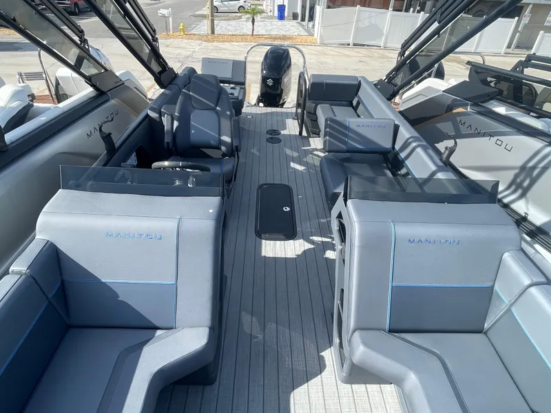 Slide: The Image of 2024 Manitou 22 Explore Switchback HSP575 boat interior with modern seating and sleek design. - 11