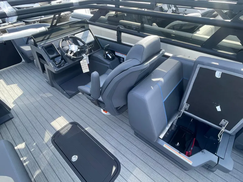 Slide: The Image of 2024 Manitou 22 Explore Switchback HSP575 boat interior with seating and steering console. - 6
