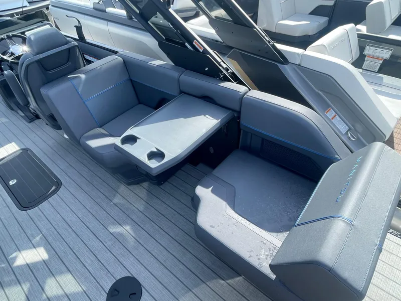 Slide: The Image of 2024 Manitou 22 Explore Switchback HSP575 boat interior with gray seating and table. - 8