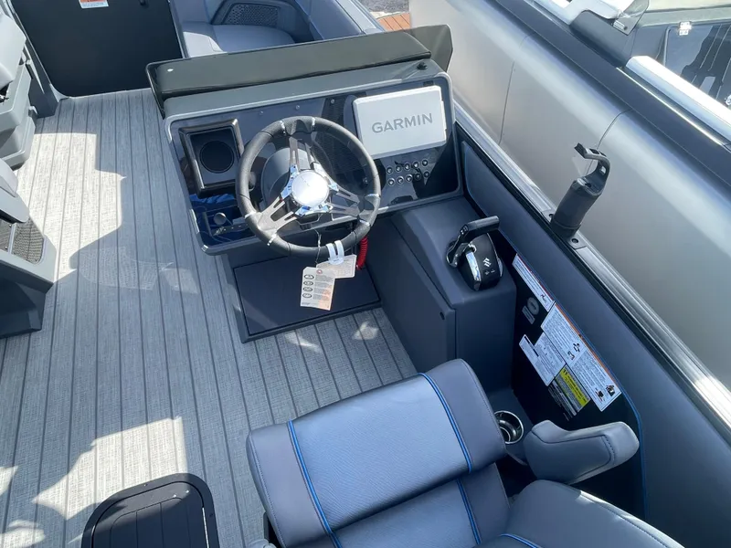 Slide: The Image of 2024 Manitou 22 Explore Switchback HSP575 boat cockpit with Garmin navigation system. - 9