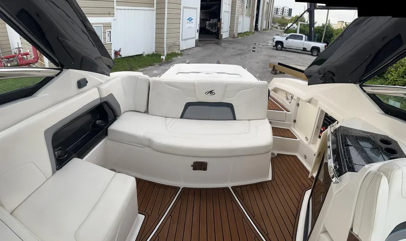 Slide: The Image of 2014 Monterey 328 Super Sport boat interior with white seating and wood flooring. - 11