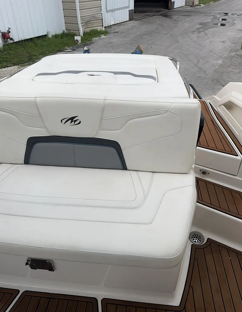 Slide: The Image of 2014 Monterey 328 Super Sport boat with white cushioned seating and wooden deck. - 12