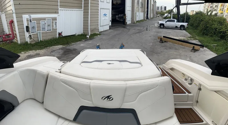 Slide: The Image of 2014 Monterey 328 Super Sport boat with white seating, docked near storage facility. - 14
