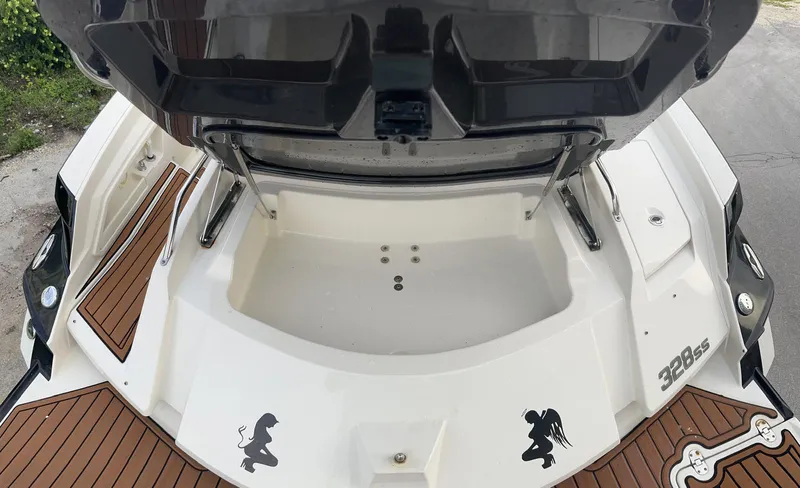 Slide: The Image of 2014 Monterey 328 Super Sport boat with open storage compartment and decorative decals. - 6