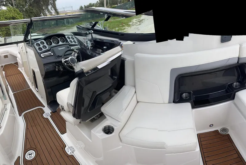 Slide: The Image of Interior of a 2014 Monterey 328 Super Sport boat with white seating and wood flooring. - 7