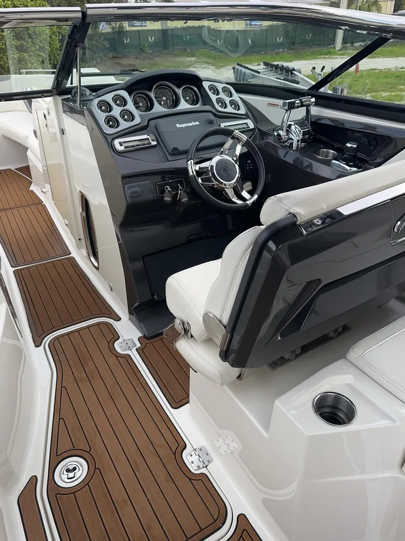 Slide: The Image of 2014 Monterey 328 Super Sport boat interior with sleek dashboard and wooden flooring. - 8