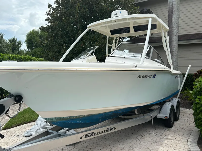 Slide: The Image of 2016 Key West 239 DFS boat on EZ Loader trailer, parked in driveway. - 2
