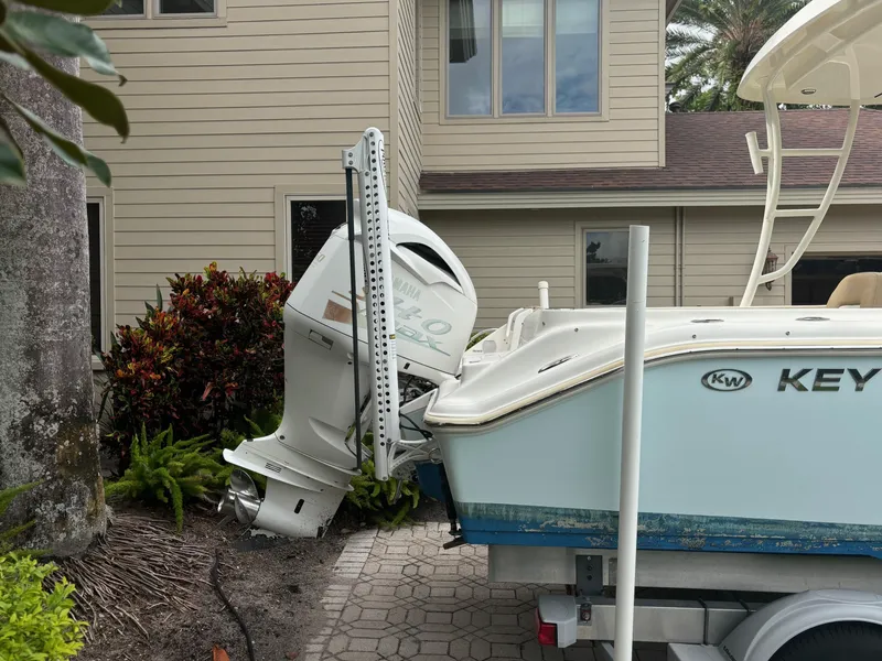 Slide: The Image of 2016 Key West 239 DFS boat with outboard motor parked near a house. - 4