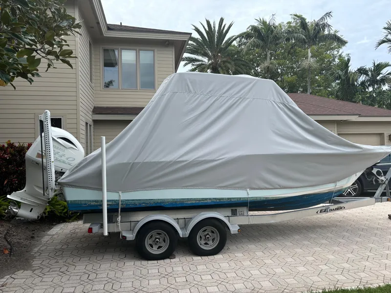 Slide: The Image of 2016 Key West 239 DFS boat covered on trailer, parked in driveway. - 8
