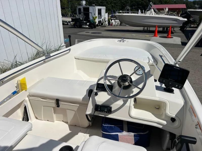 Slide: The Image of 2018 Boston Whaler 170 Super Sport boat interior with steering wheel and seating. - 2