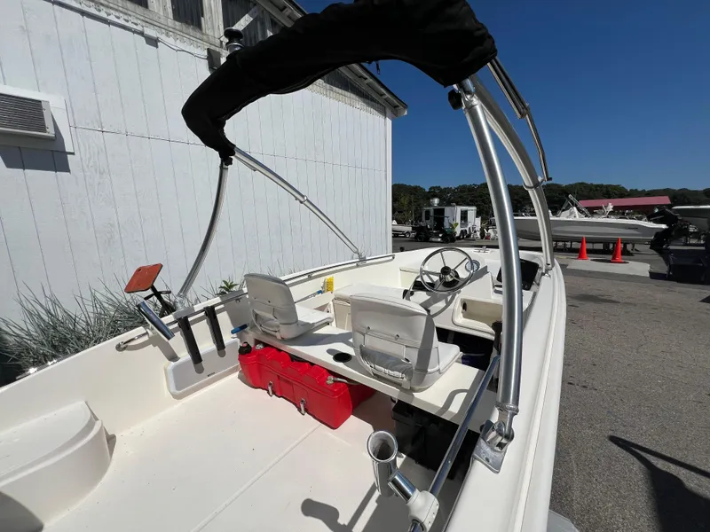 Slide: The Image of 2018 Boston Whaler 170 Super Sport boat with canopy, parked outdoors. - 3