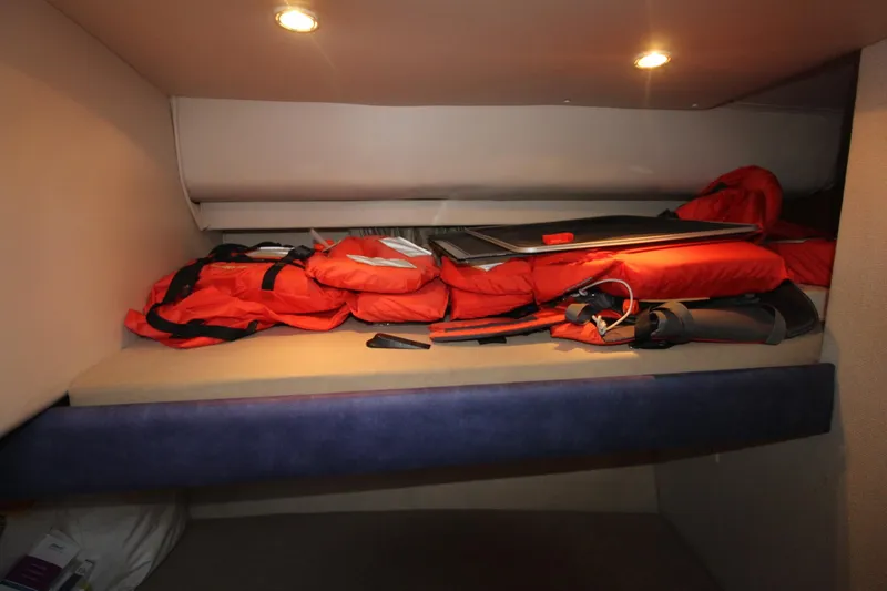 Slide: The Image of 1995 Carver 370 Voyager cabin with life jackets and equipment on a bunk bed. - 19