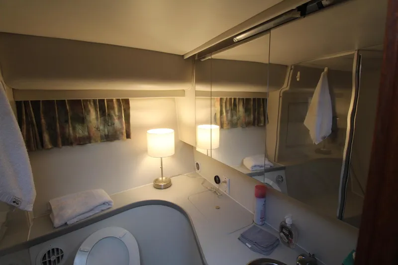 Slide: The Image of Bathroom interior of 1995 Carver 370 Voyager yacht, featuring mirror, lamp, and toiletries. - 25