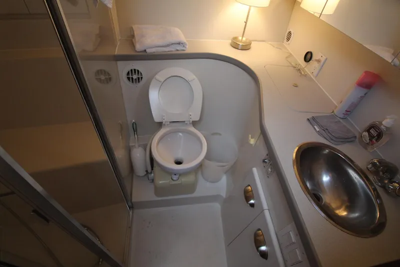 Slide: The Image of Compact bathroom in a 1995 Carver 370 Voyager yacht, featuring a toilet, sink, and countertop. - 27
