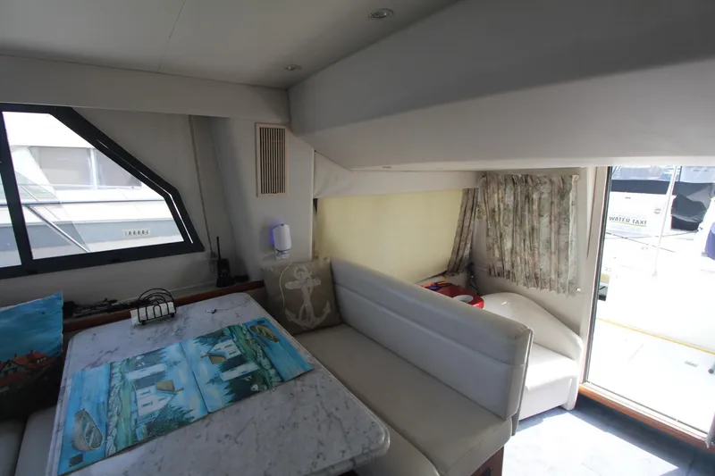 Slide: The Image of Interior of 1995 Carver 370 Voyager yacht with dining area and window view. - 38