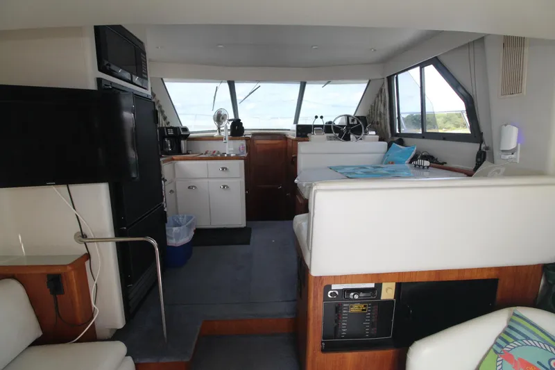 Slide: The Image of Interior of a 1995 Carver 370 Voyager yacht, featuring helm, seating, and kitchenette. - 40