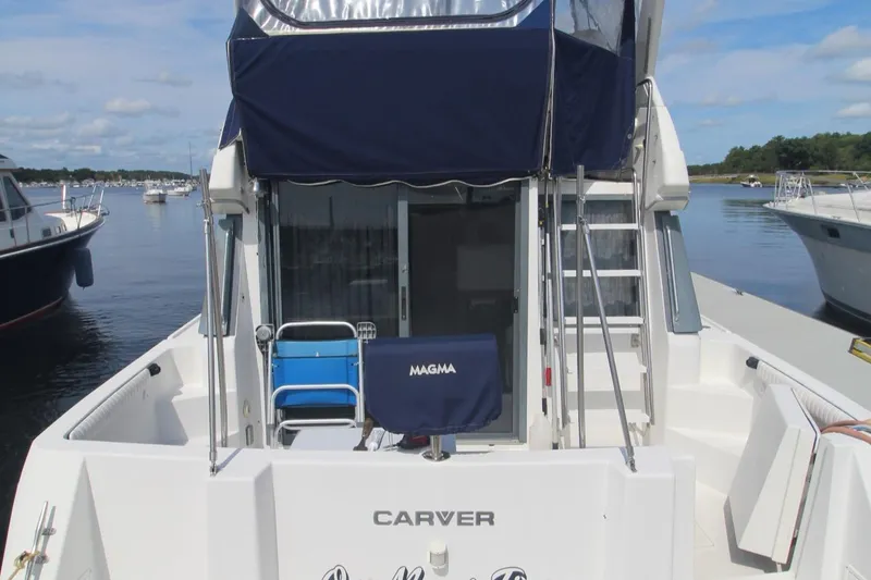 Slide: The Image of 1995 Carver 370 Voyager boat docked, featuring a spacious deck and canopy. - 42