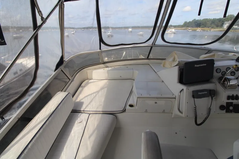 Slide: The Image of 1995 Carver 370 Voyager boat interior with navigation equipment and seating, overlooking a serene water view. - 9