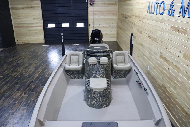 Slide: The Image of 2025 War Eagle 2170 Blackhawk boat in showroom with wood paneling. - 11