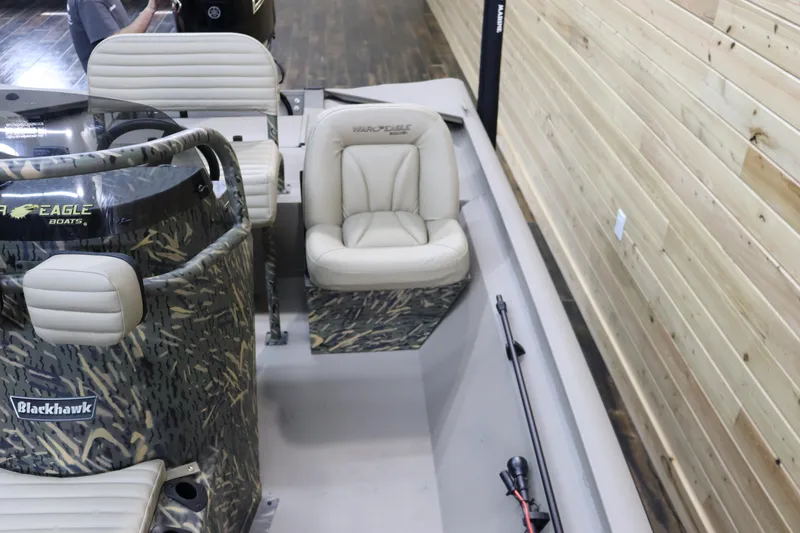 Slide: The Image of 2025 War Eagle 2170 Blackhawk boat interior with camo design and beige seating. - 14
