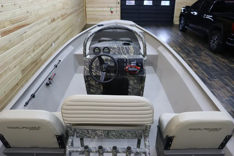 Slide: The Image of 2025 War Eagle 2170 Blackhawk boat interior with camouflage design in a wooden garage. - 16