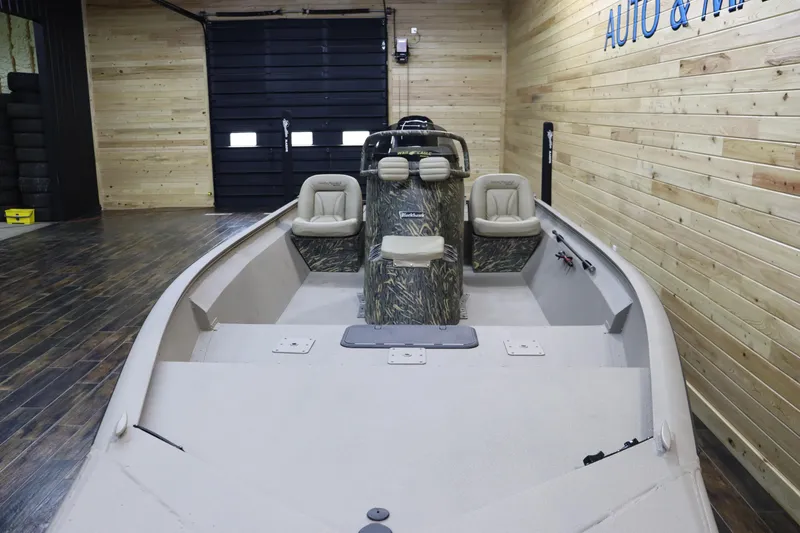 Slide: The Image of 2025 War Eagle 2170 Blackhawk boat in wooden showroom, featuring dual seats and camouflage console. - 9