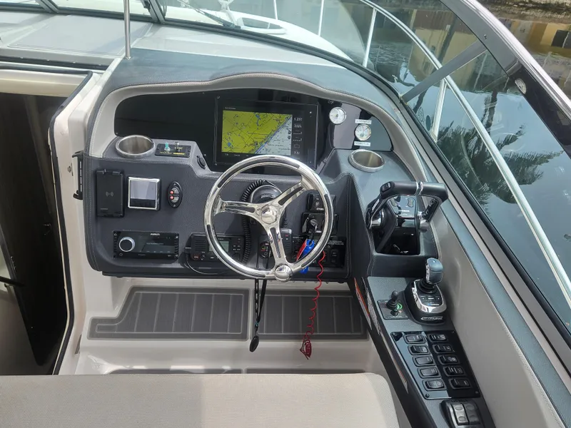 Slide: The Image of 2022 Regal 33 XO boat helm with navigation display and controls. - 11