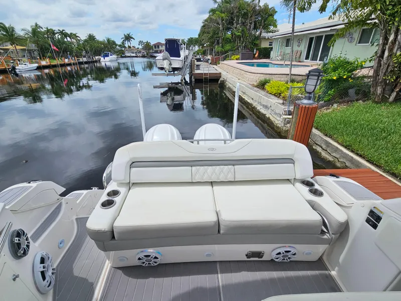Slide: The Image of 2022 Regal 33 XO boat with luxurious seating by a serene waterfront. - 18