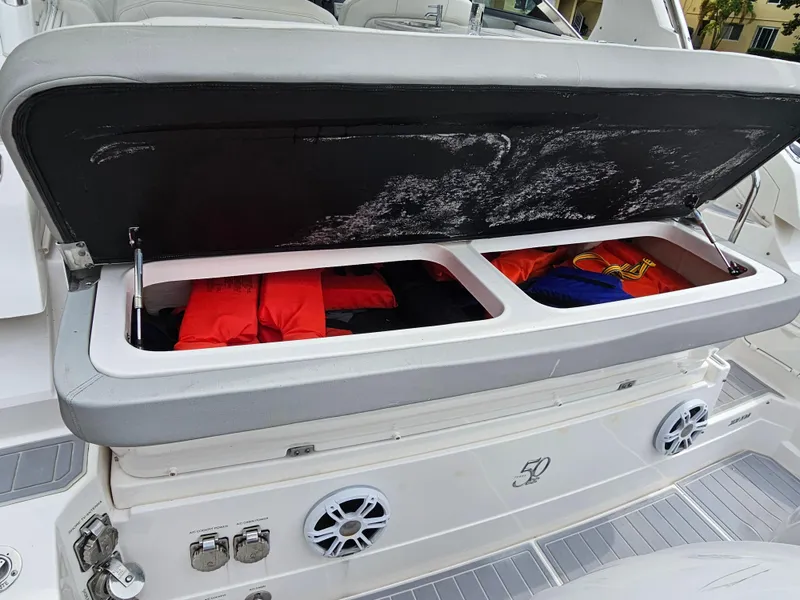 Slide: The Image of Open storage compartment on 2022 Regal 33 XO boat with life jackets inside. - 20