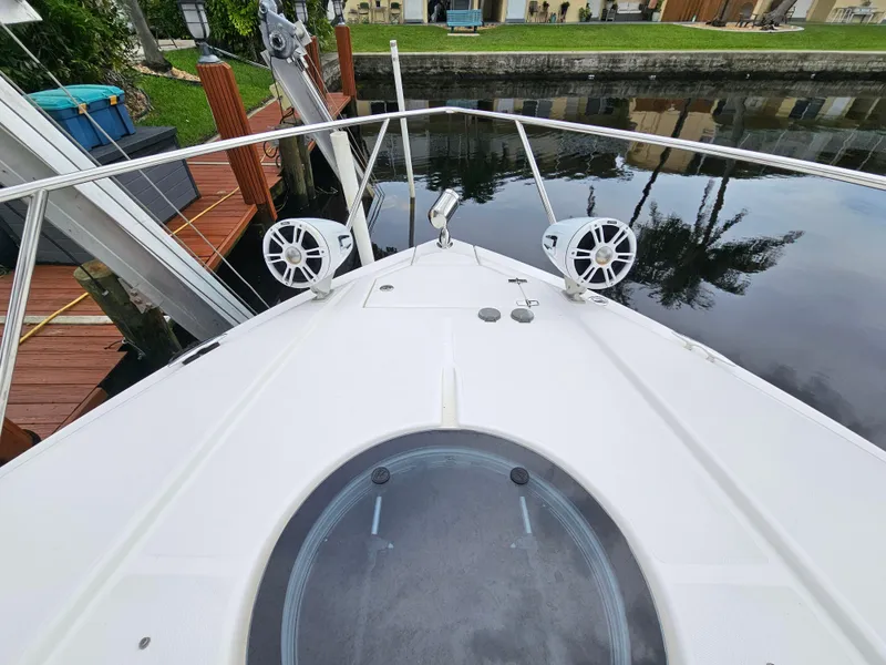 Slide: The Image of 2022 Regal 33 XO boat bow with speakers, docked by a canal. - 3