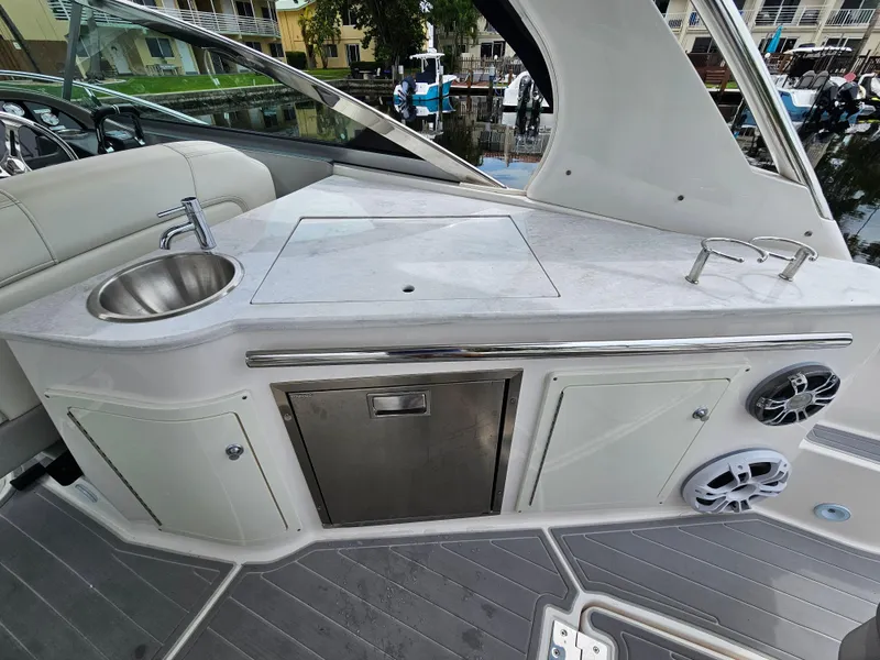 Slide: The Image of 2022 Regal 33 XO boat interior with kitchenette, sink, and storage. - 9