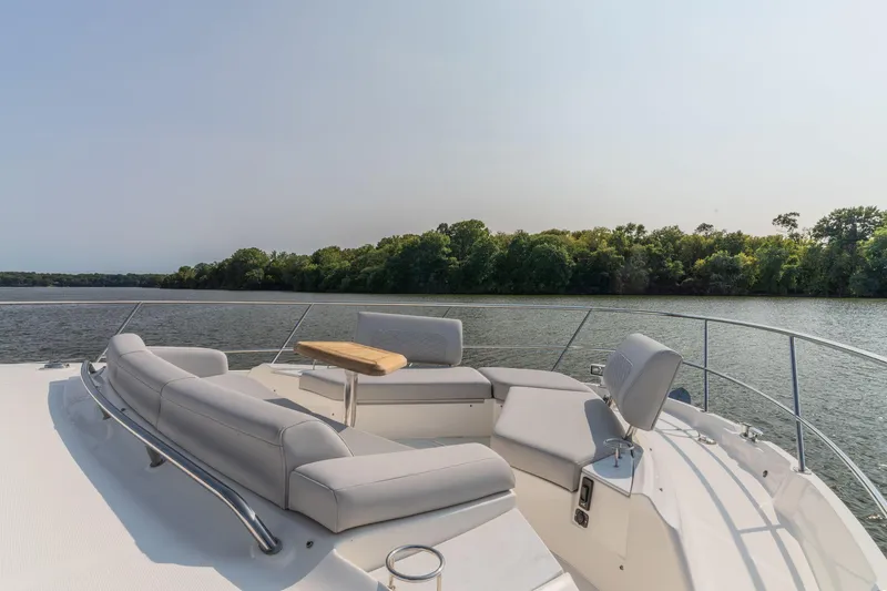 Slide: The Image of Luxurious 2018 Sea Ray L550 Fly yacht with spacious deck seating on a serene lake. - 13