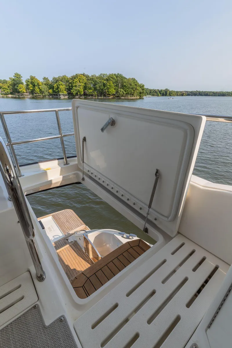 Slide: The Image of 2018 Sea Ray L550 Fly yacht with open hatch, scenic lake view. - 19