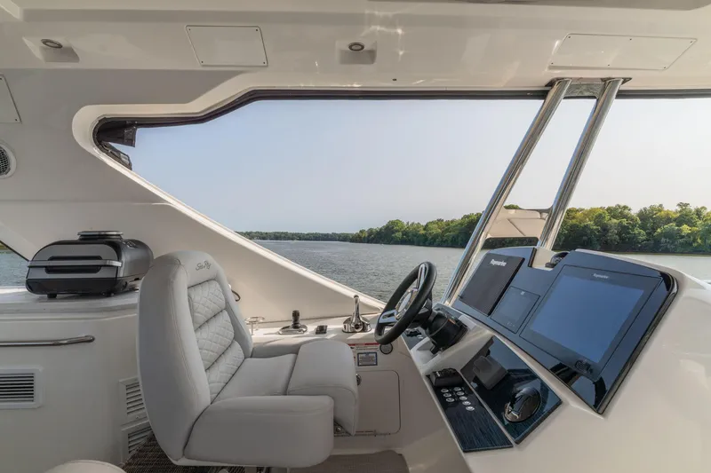Slide: The Image of Interior view of 2018 Sea Ray L550 Fly yacht cockpit with river scenery. - 21