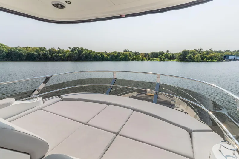 Slide: The Image of 2018 Sea Ray L550 Fly yacht with spacious deck overlooking serene water and lush greenery. - 23
