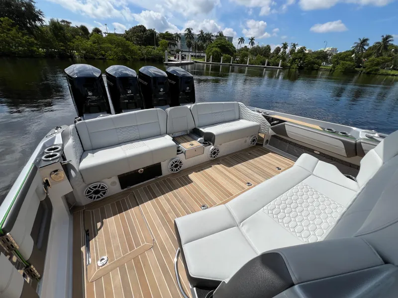 Slide: The Image of 2024 Nor-Tech 500 Sport boat interior with luxurious seating and powerful engines on a scenic waterway. - 12