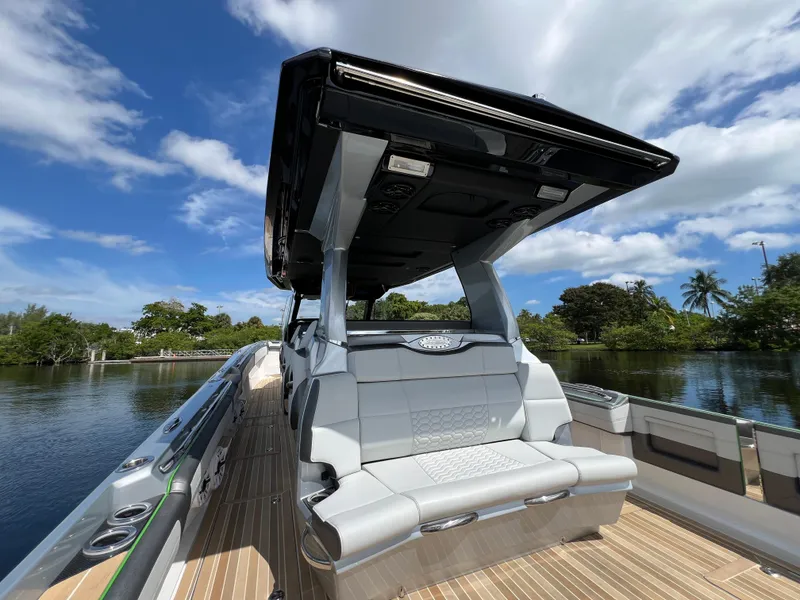 Slide: The Image of 2024 Nor-Tech 500 Sport boat with sleek seating and canopy on a sunny day. - 16