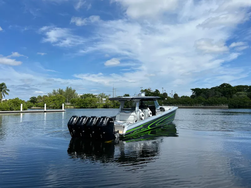 Slide: The Image of 2024 Nor-Tech 500 Sport boat with multiple engines on a calm waterway. - 2