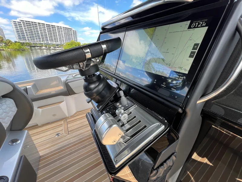 Slide: The Image of 2024 Nor-Tech 500 Sport boat cockpit with advanced navigation system and steering wheel. - 24
